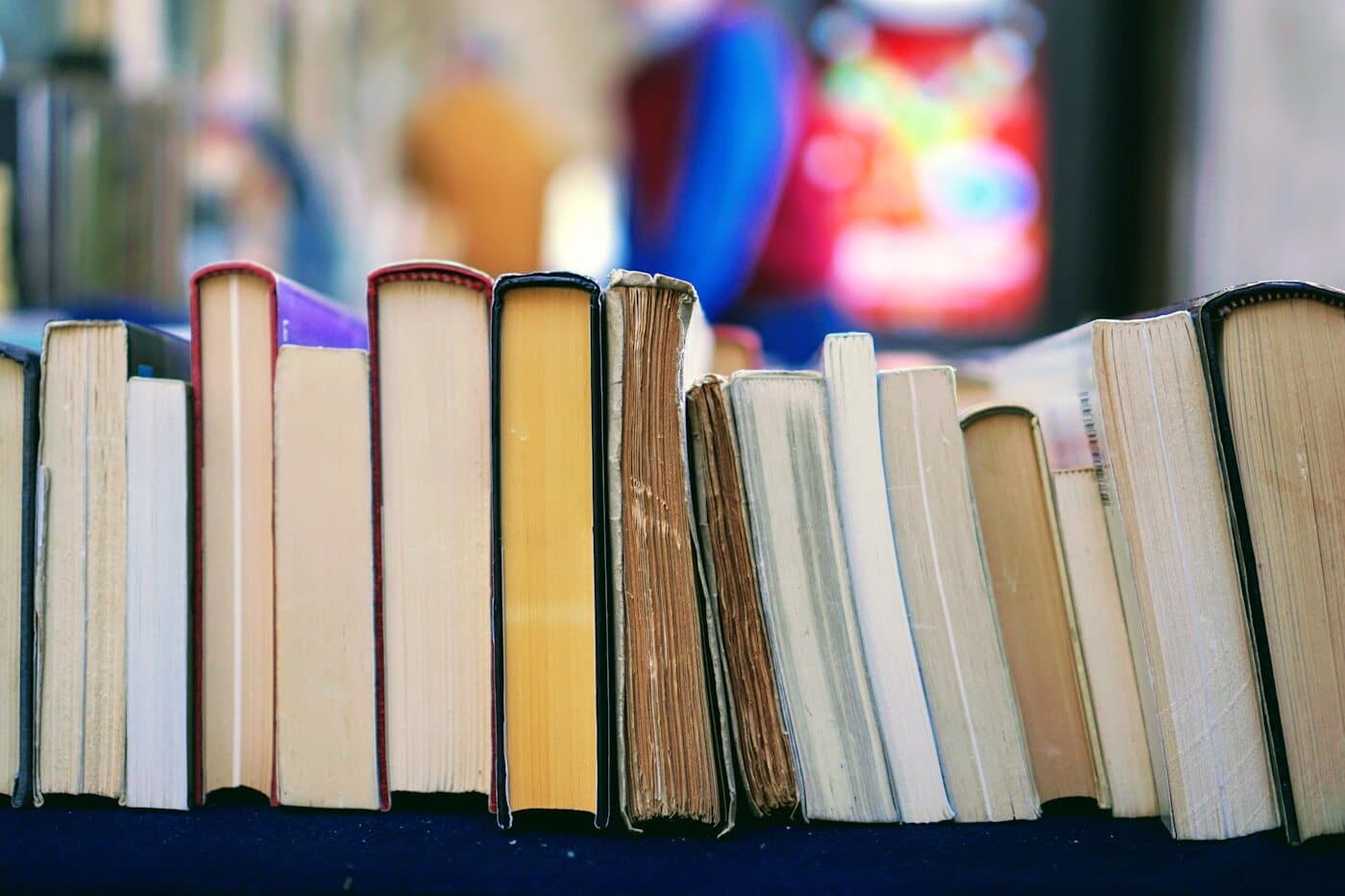 The fore-edges of a row of hardback books on a shelf